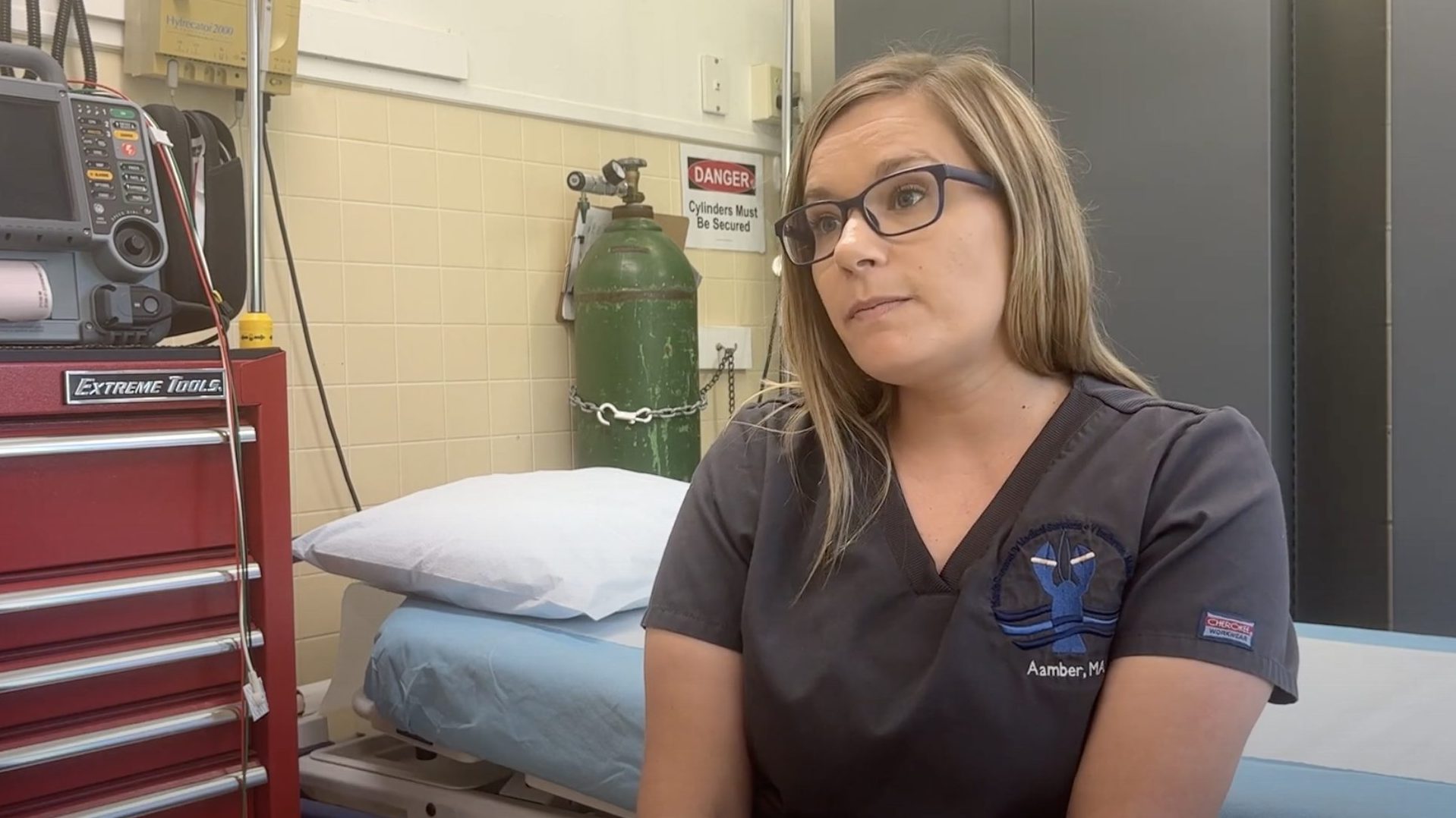 Aamber sitting in front of a medical gurney.